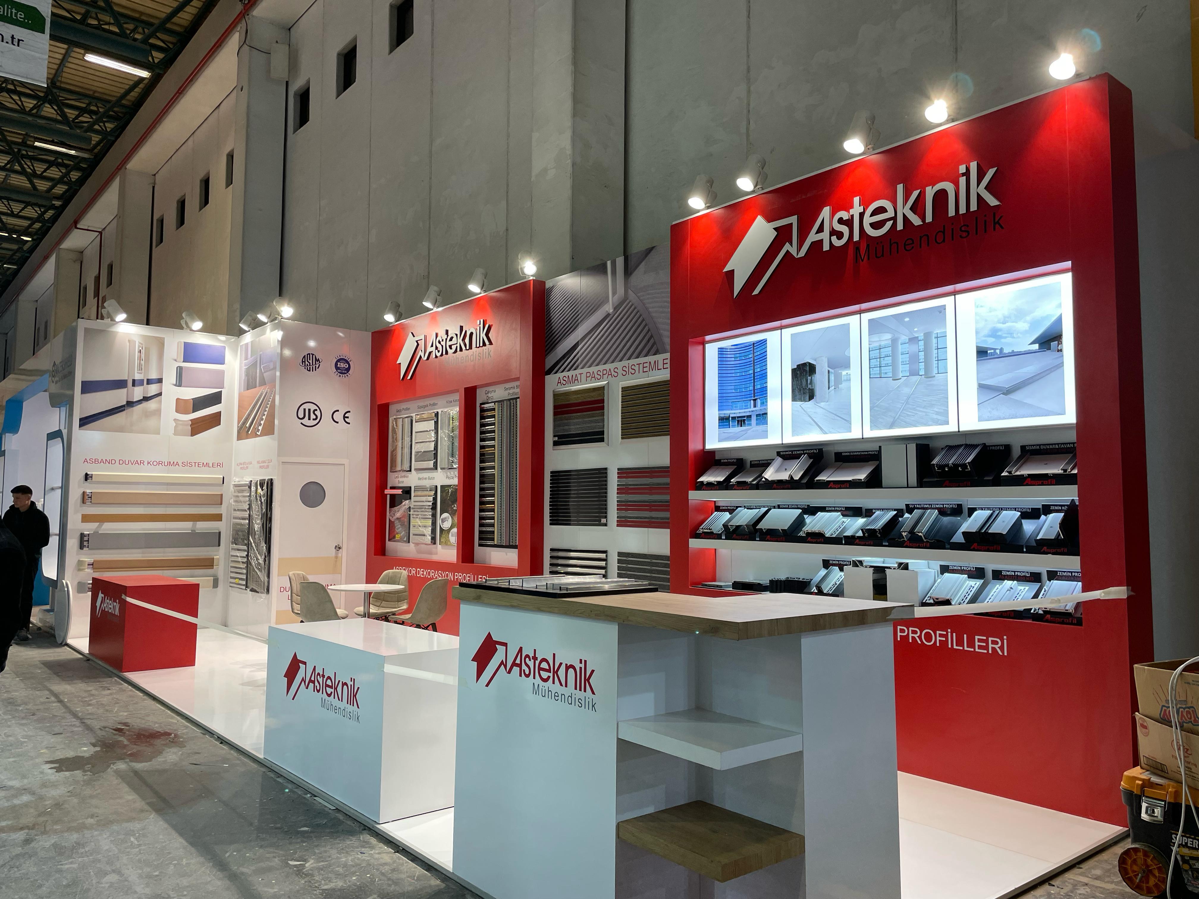 Asteknik exhibition stand at Yapı Istanbul 2025, featuring a strong red and white corporate identity with illuminated branding and glossy white flooring.