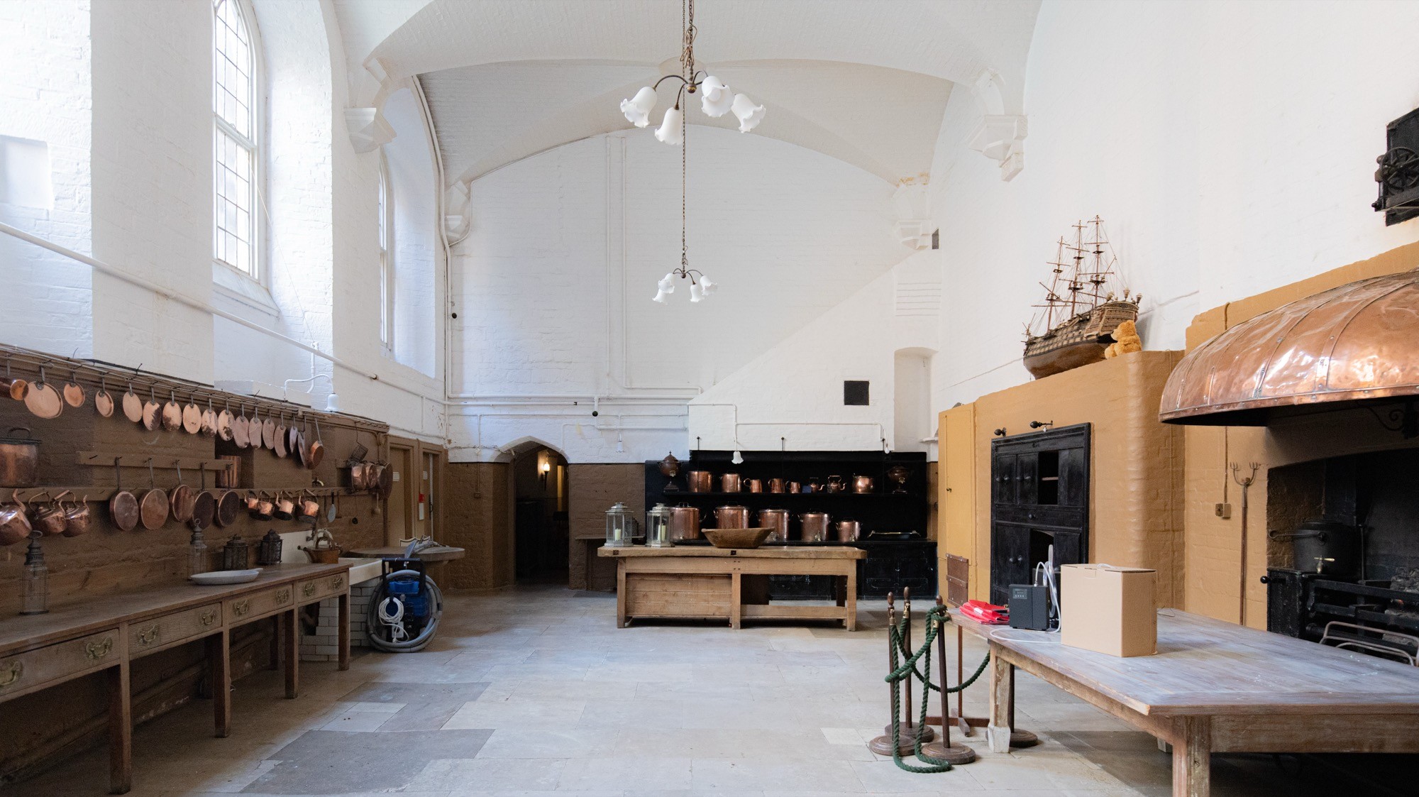 Two classic volkswagen beetles, one green, one cream.