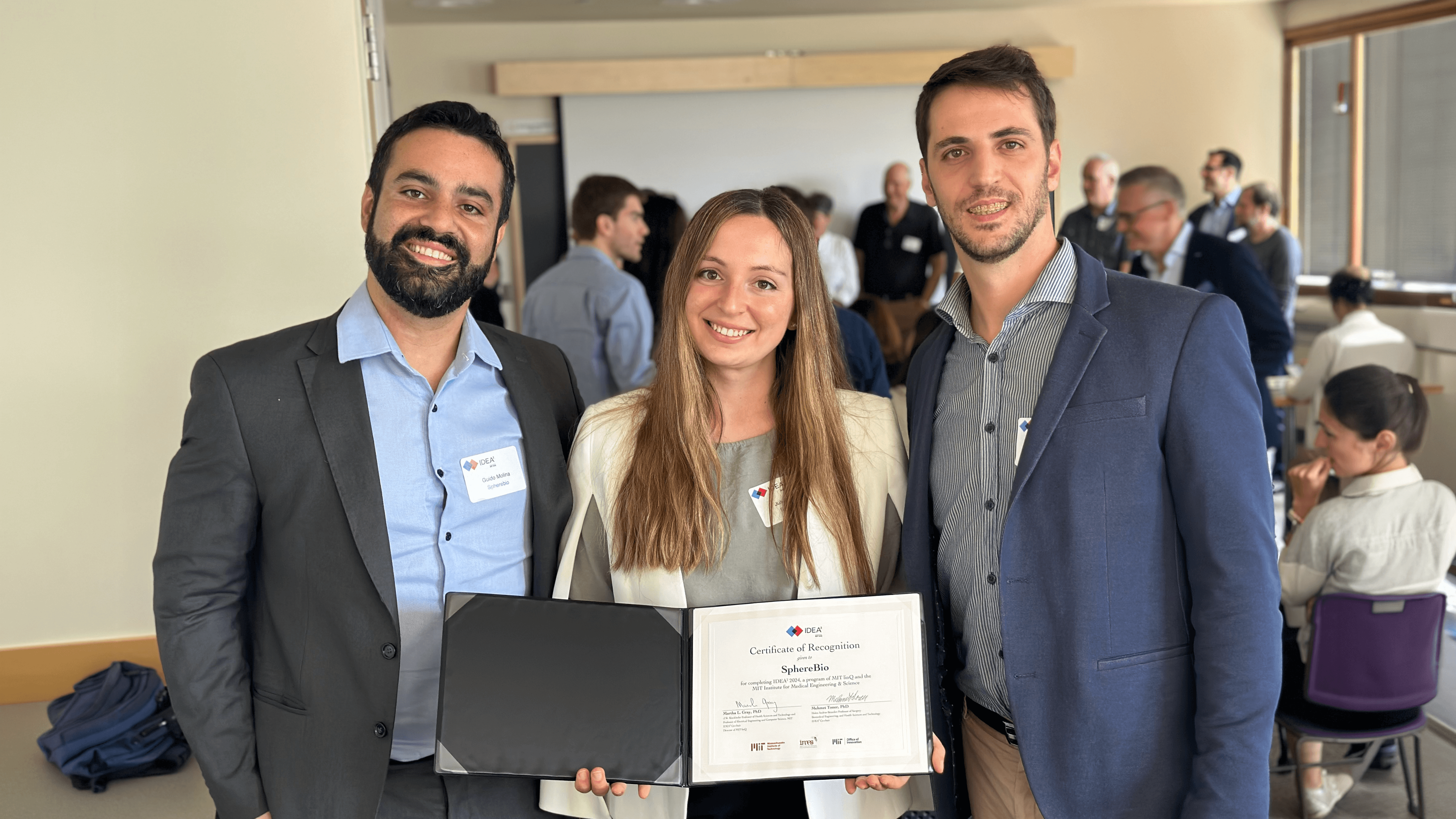 Three founders smiling in a conference room, holding a certificate of recognition.