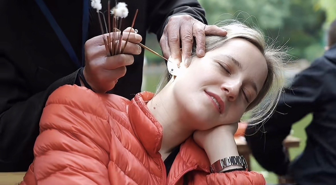 Foreign tourist experiencing traditional ear cleaning at Chengdu People's Park