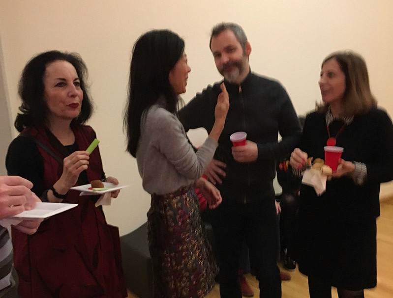 a group of three women and a man is having a drink and a snack