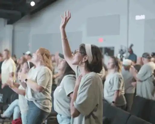 Congregation worshiping with hands raised during a service