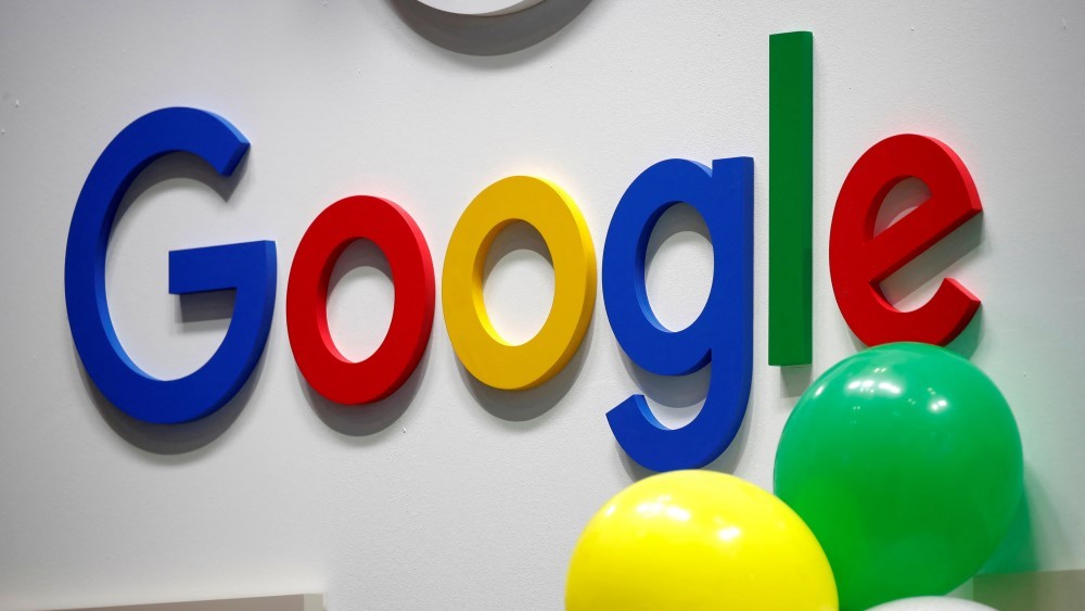 Google logo in vibrant blue, red, yellow, and green, letters displayed on a white background, with yellow and green balloons positioned close to the image.