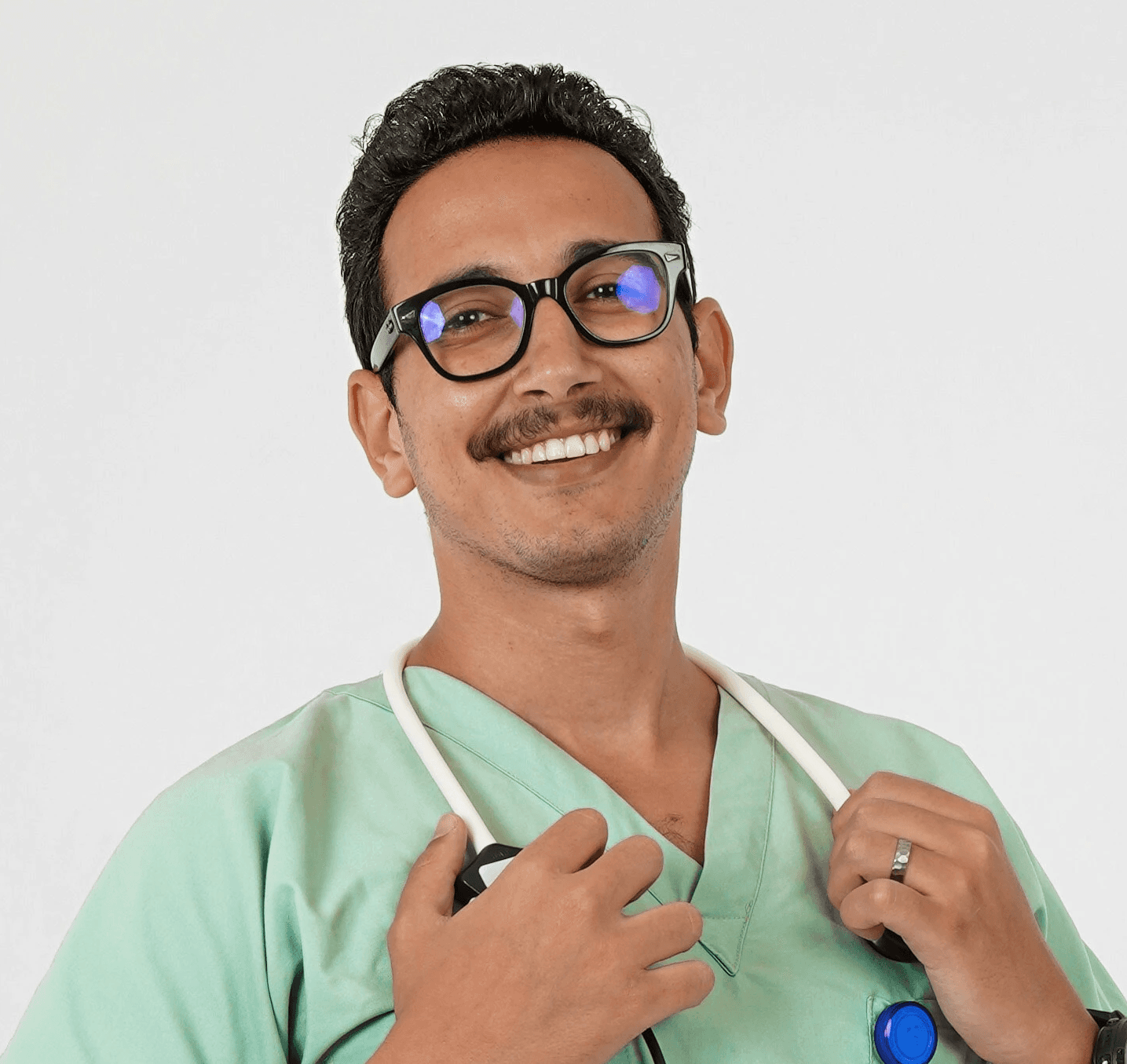 A man in a green scrub suit holding a toothbrush