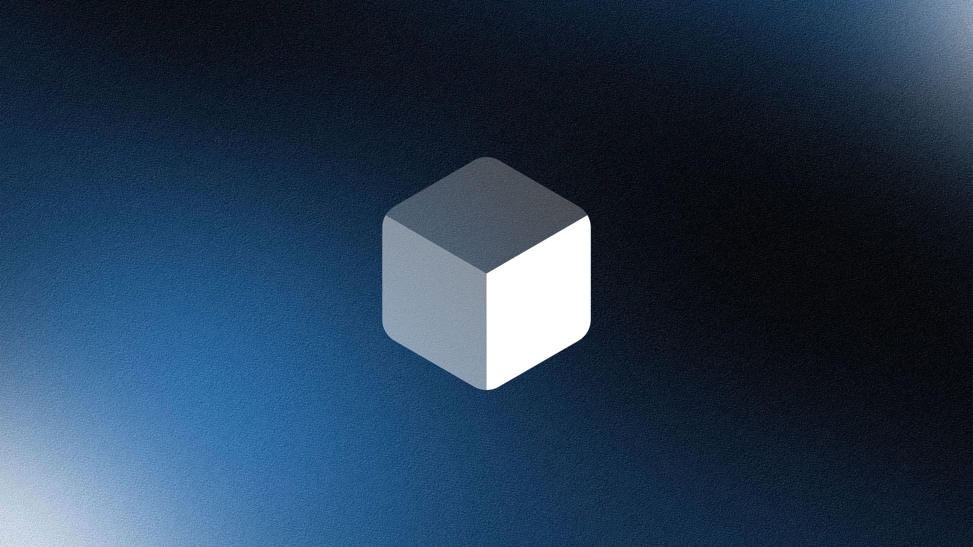 Man wearing a beige cap and dark shirt working on a laptop at a wooden desk with a plant in the background.