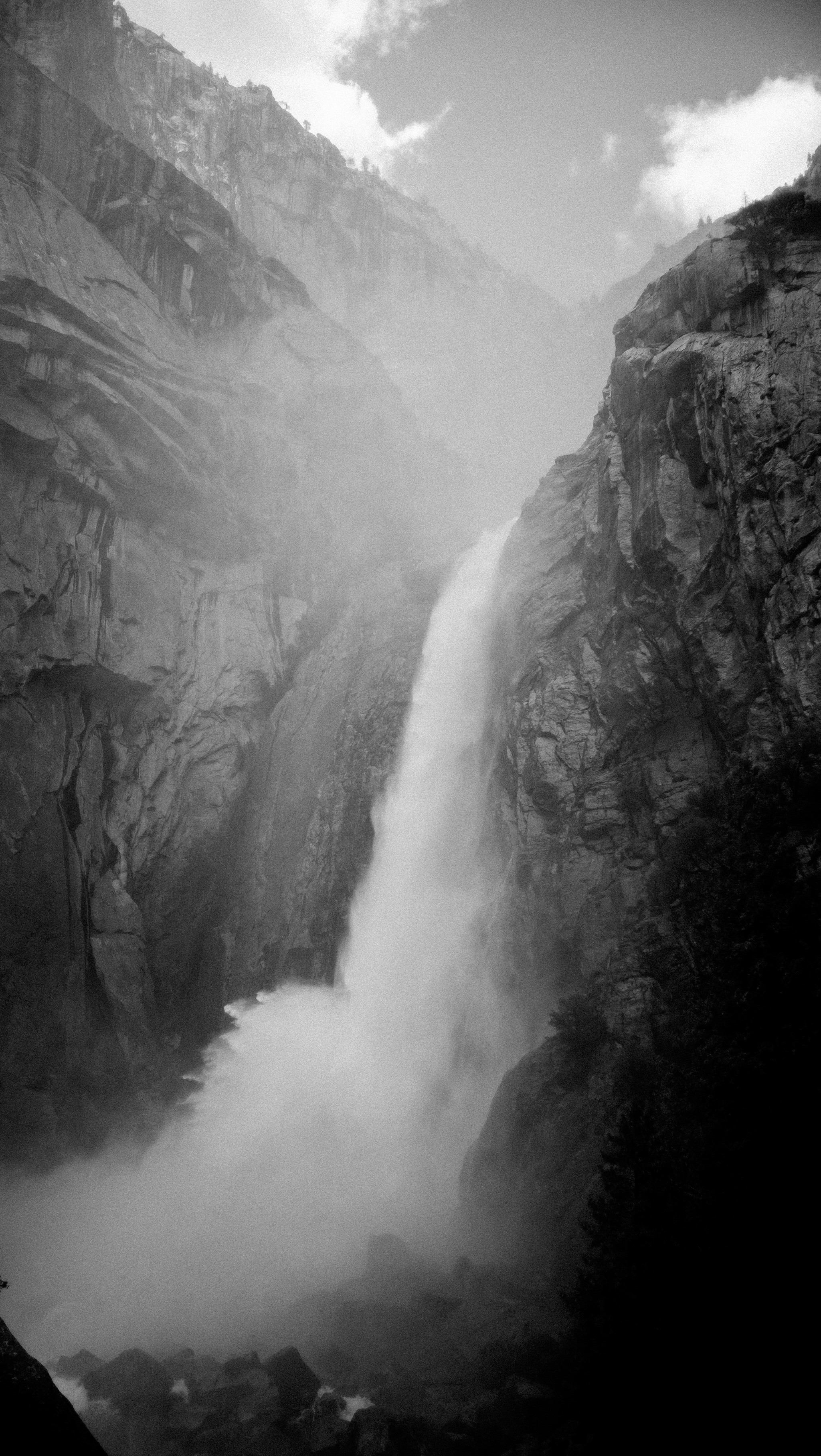 a very tall waterfall in the middle of a mountain