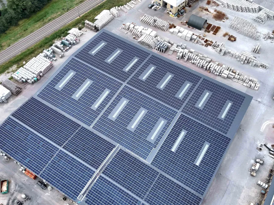 Großes Dach mit Solarmodulen und Oberlichtern für Energieeffizienz.