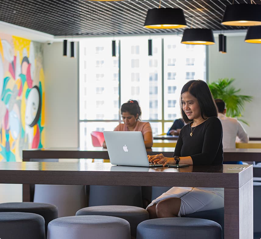 A woman working at a coworking spot in myOffice in a relaxed atmosphere with a combination of natural and artificial light. 