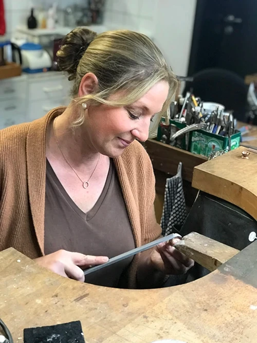 Goldschmiedemeistering Susanne Kunzmann sitzt an ihrer Werkbank und arbeitet an einem einzigartigen Schmuckstück