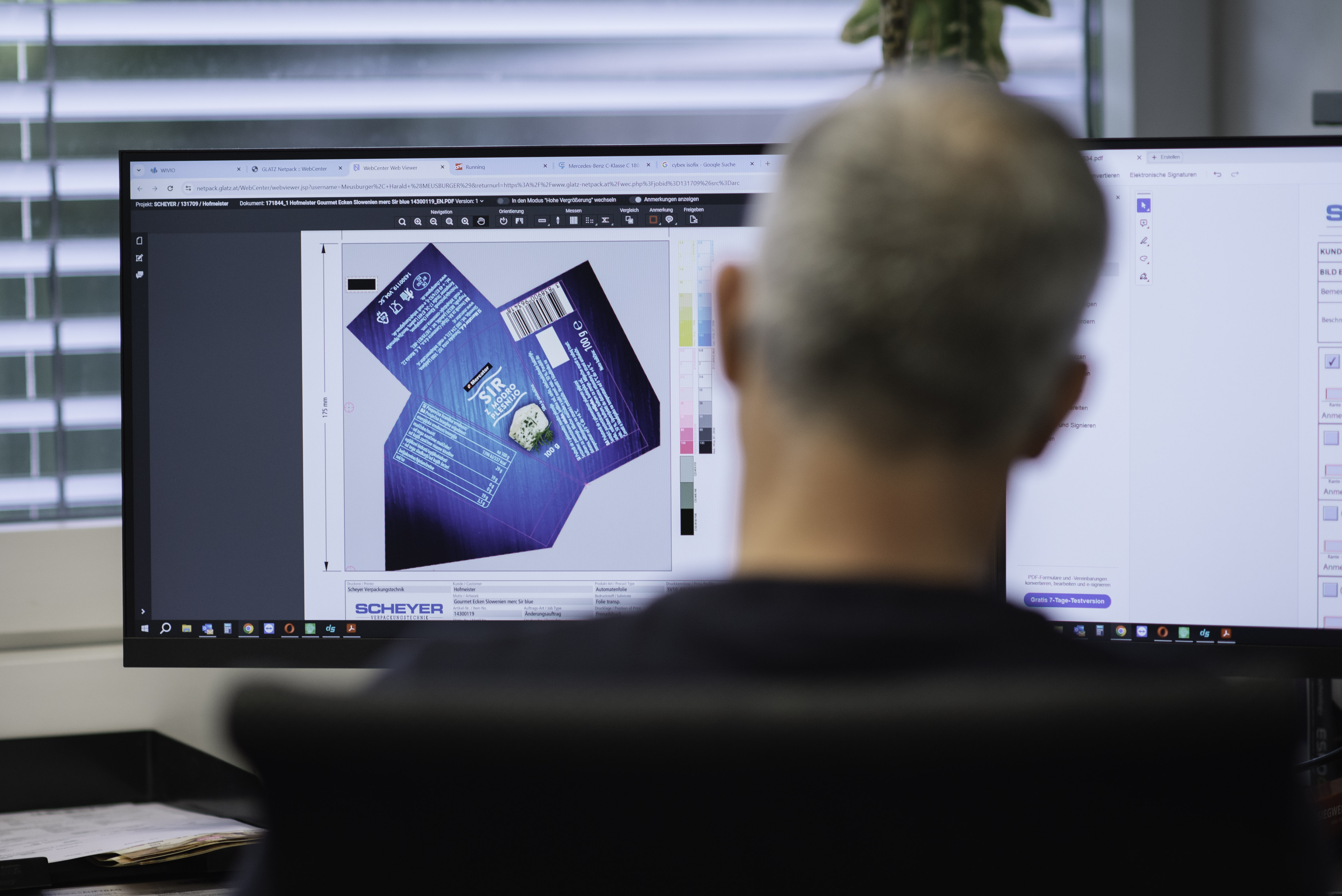 Scheyer employee reviewing packaging design details on a computer screen, ensuring accuracy before production.