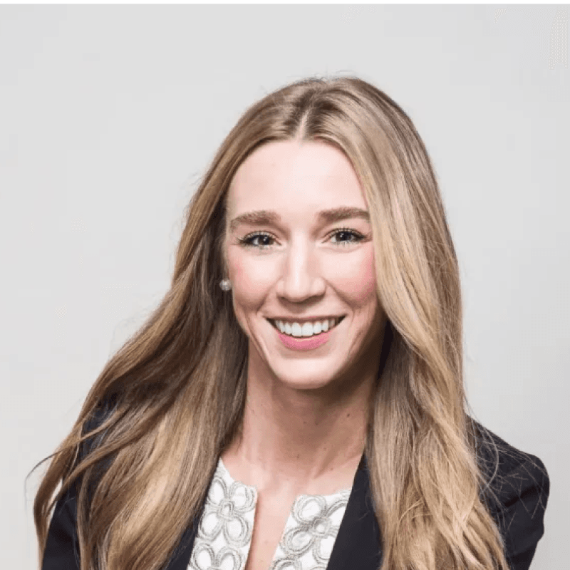 Portrait of a smiling team member with long blonde hair wearing a patterned top