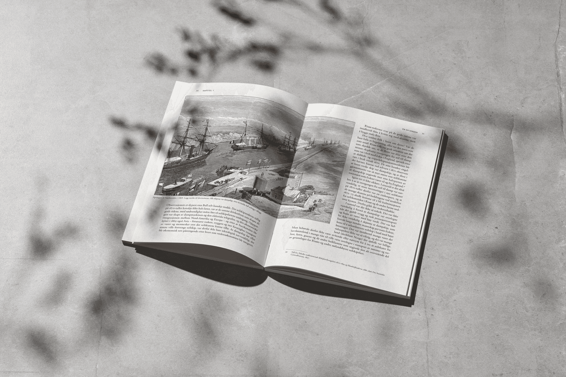 Open book with a historical illustration of ships, placed on a textured surface with shadows.