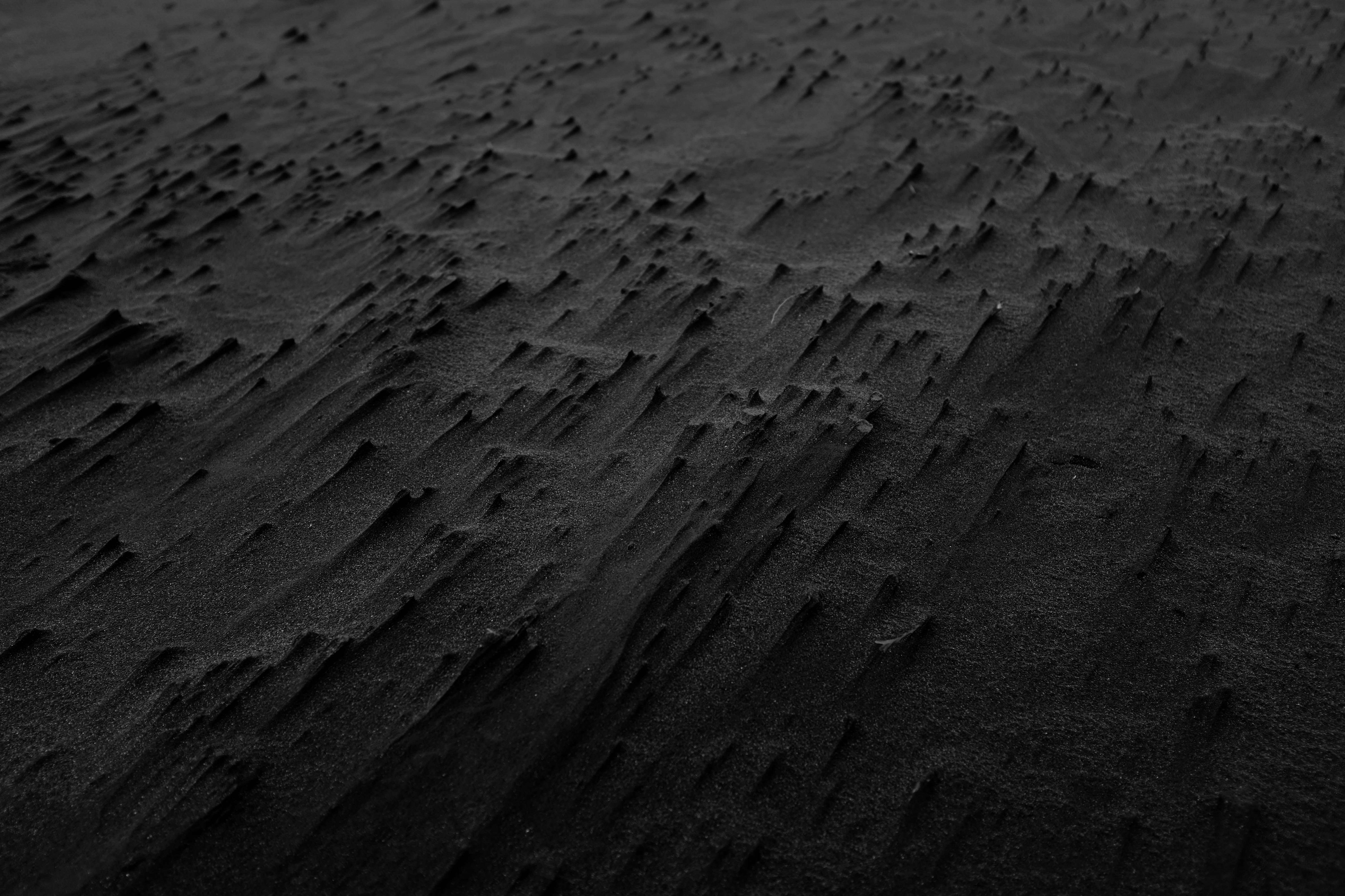 a black and white photo of sand and water