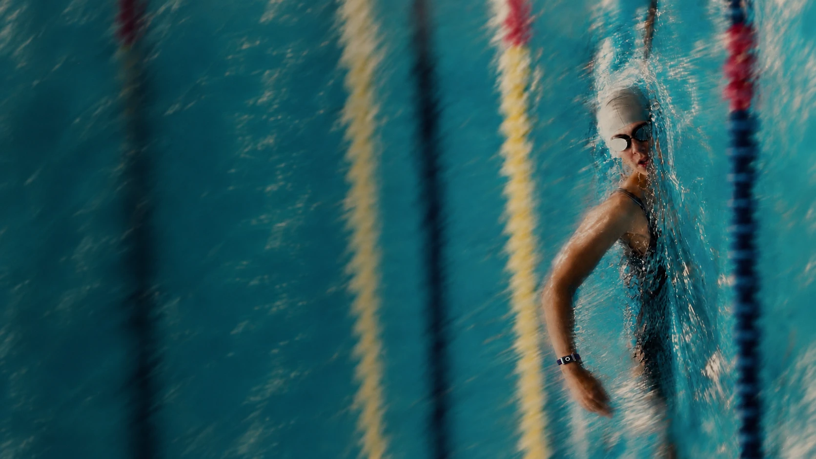 Black-and-white photograph of a swimmer emerging from a pool wearing Alloop Trio