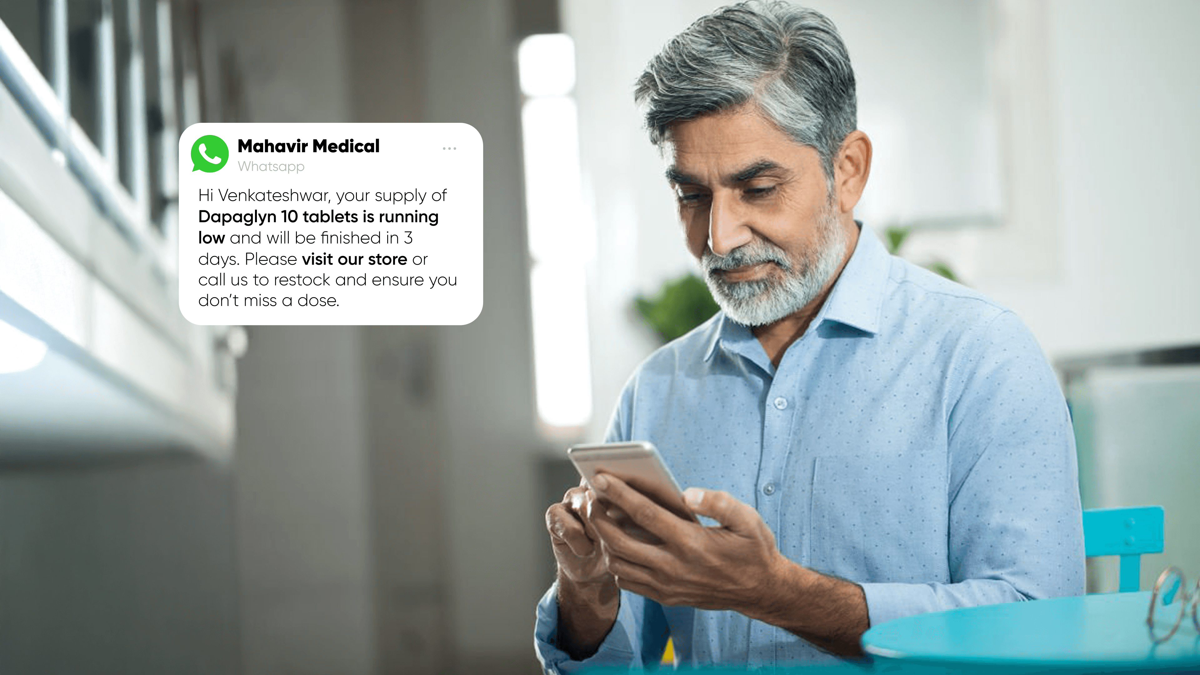 A senior man with grey hair and a beard, sitting at home, reading a medicine reminder message on his smartphone. The message is sent via WhatsApp by Mahavir Medical, reminding him about the low stock of his medication and encouraging him to visit the store or call to restock, showcasing personalized pharmacy services. - Medicine delivery trends in India - Online pharmacy challenges - Future of pharmacy technology - Local pharmacy innovations - Pharmacy software benefits - E-pharmacy market India - Competing with online pharmacies - Marg billing software alternatives - Ezo billing machine comparison - Apollo Pharmacy app review