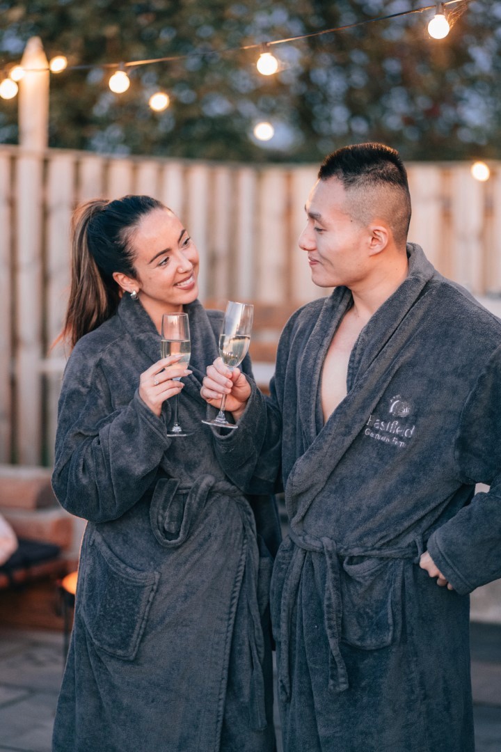 A couple in dressing gowns drinking champagne.