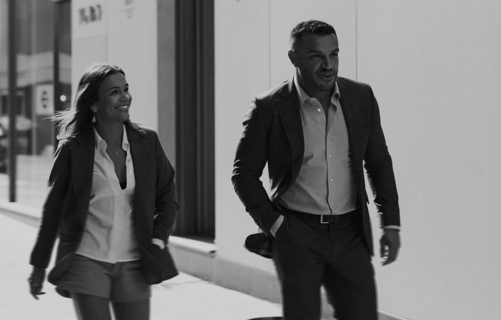 Male lawyer and female assisitant walking down hospitality