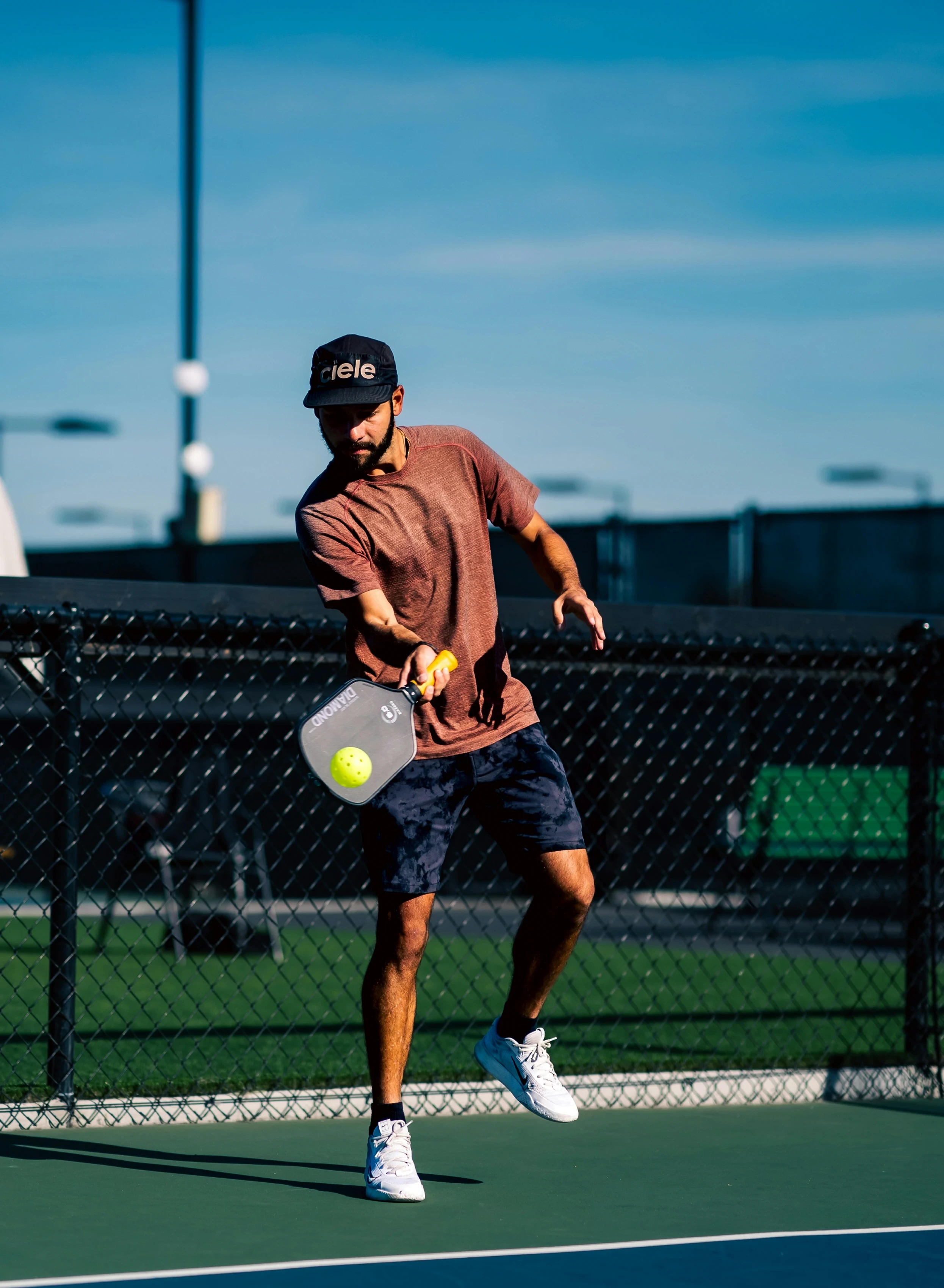Player hitting a pickleball on an outdoor court