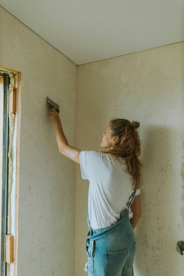 Mariana spackles a wall while restoring one of the guesthouse bedrooms.