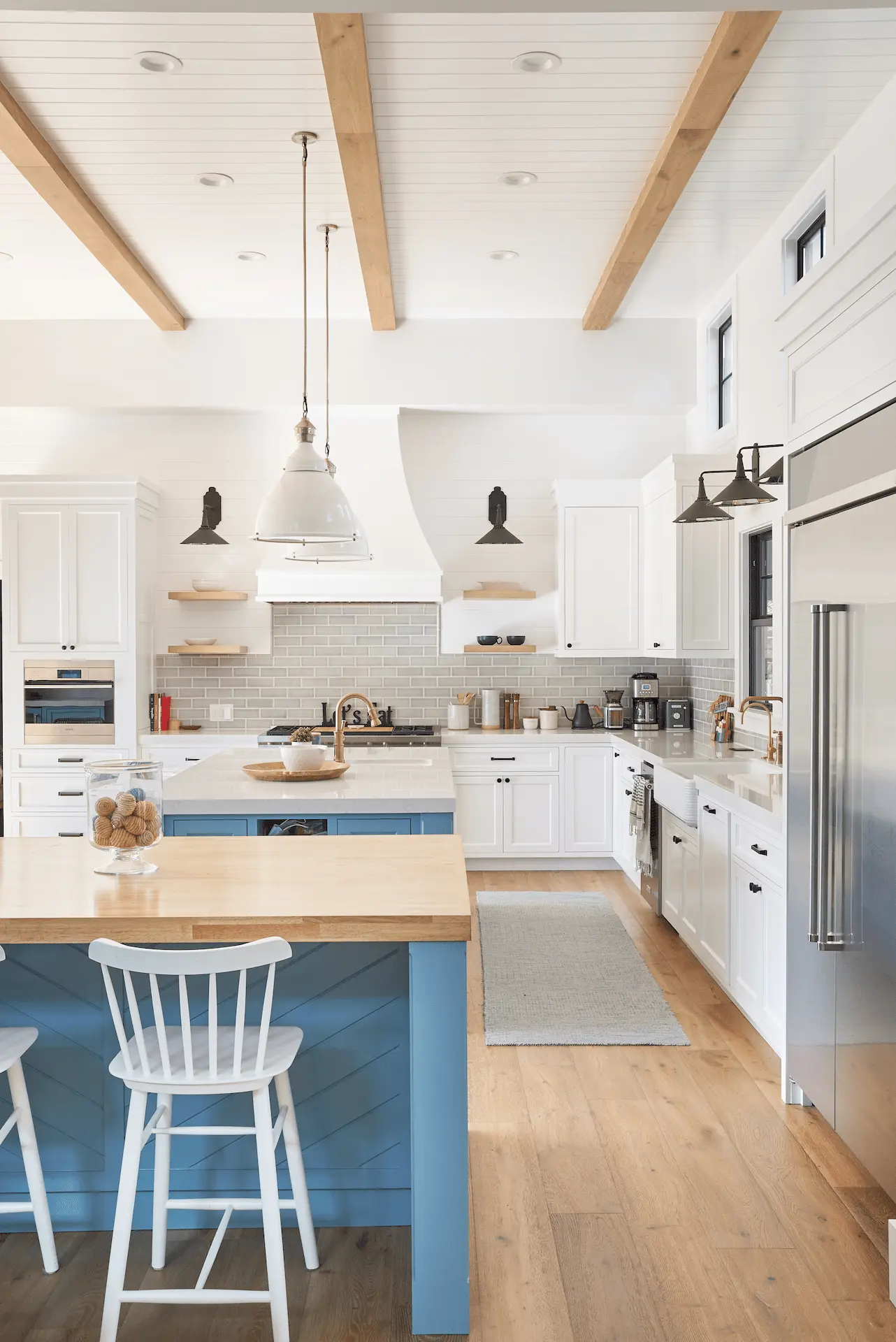 Bright kitchen with blue island and wooden ceiling beams in North Tustin Remodel & Addition. Photo by Todd Huge.