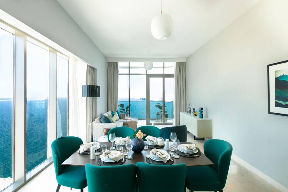 Spacious modern living room with a large window, highlighting bright interiors and stylish decor in Anwa Omniyat Maritime City.