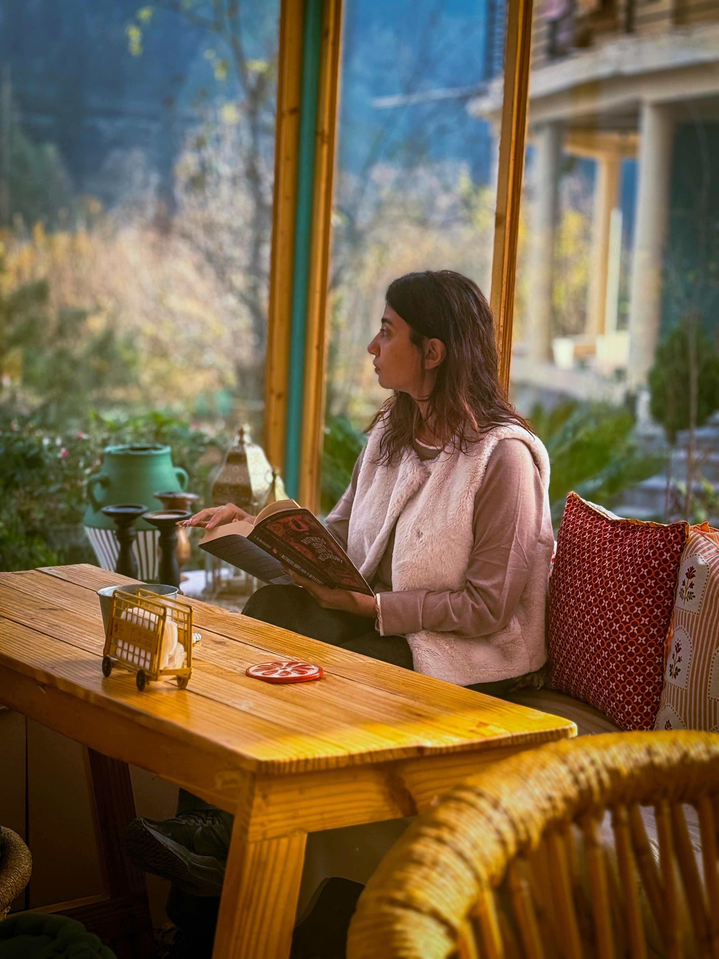 sitting woman carrying backpack overlooking canyon during daytime