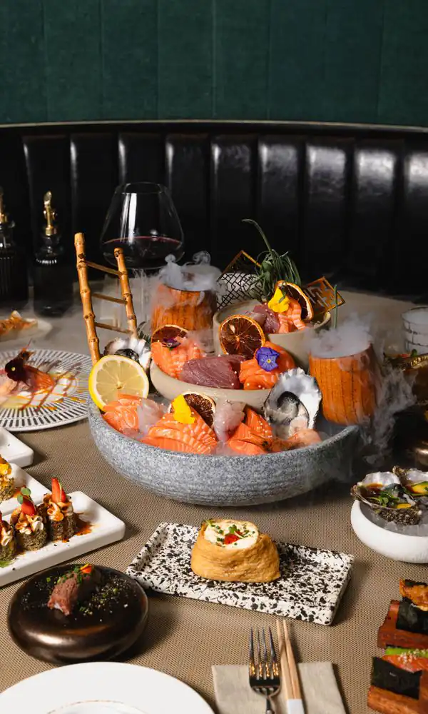 Buttoned black leather banquette and a smoking sashimi platter