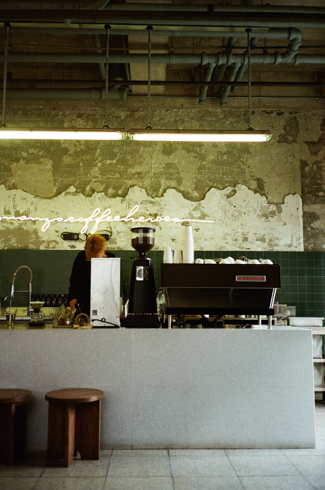 Coffee bar with espresso machine and green concrete wall