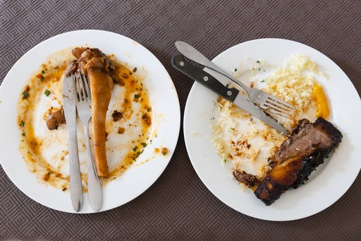 Empty plates and food scraps. Knives and forks together