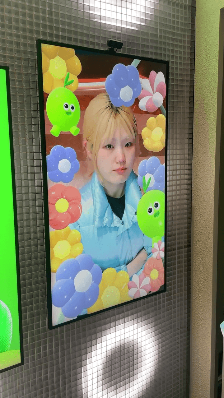 방문객의 얼굴을 올리브영 캐릭터와 형형색색의 꽃으로 장식한 인터랙티브 포토 프레임