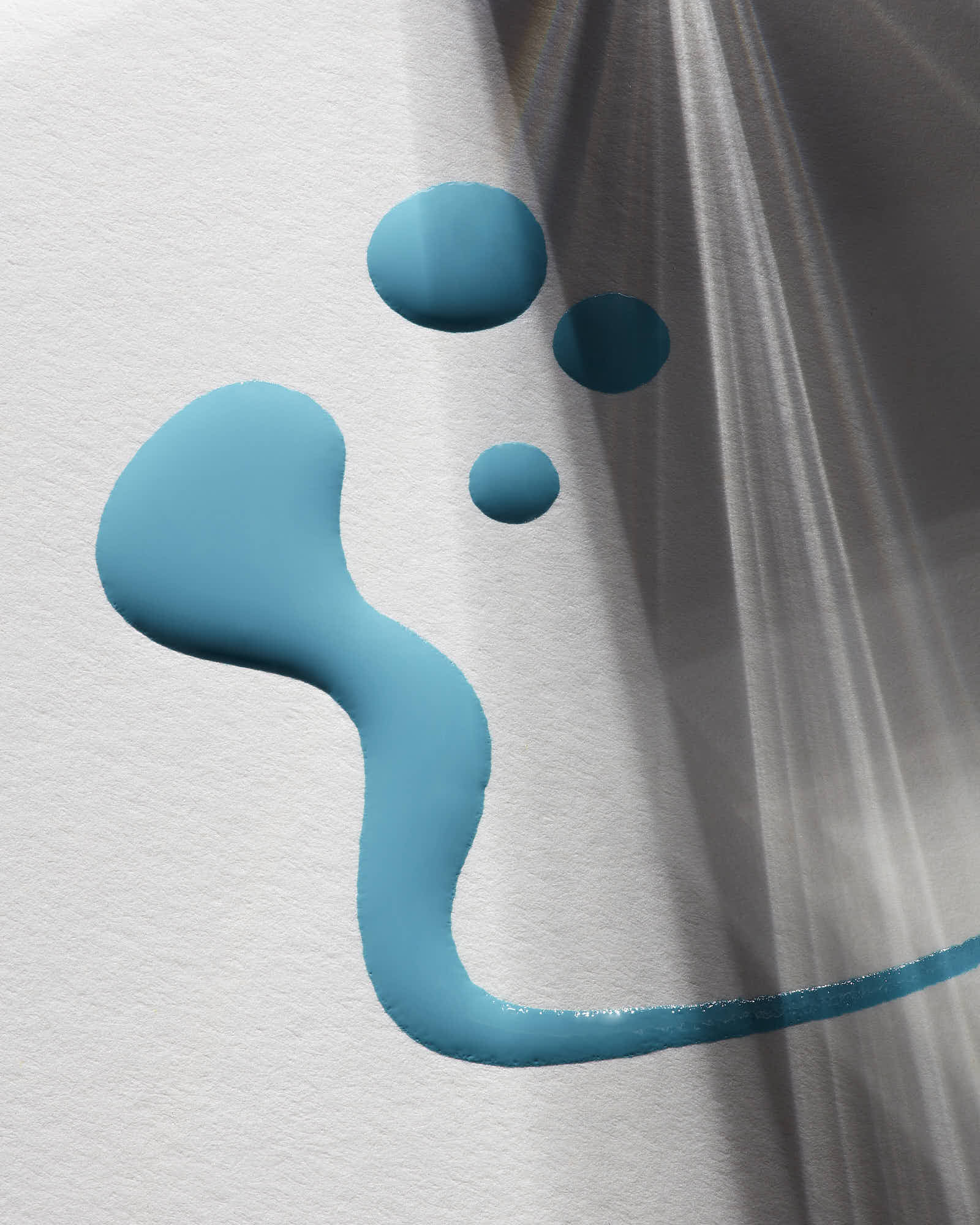 A close-up of a smooth surface featuring a playful arrangement of blue liquid droplets.