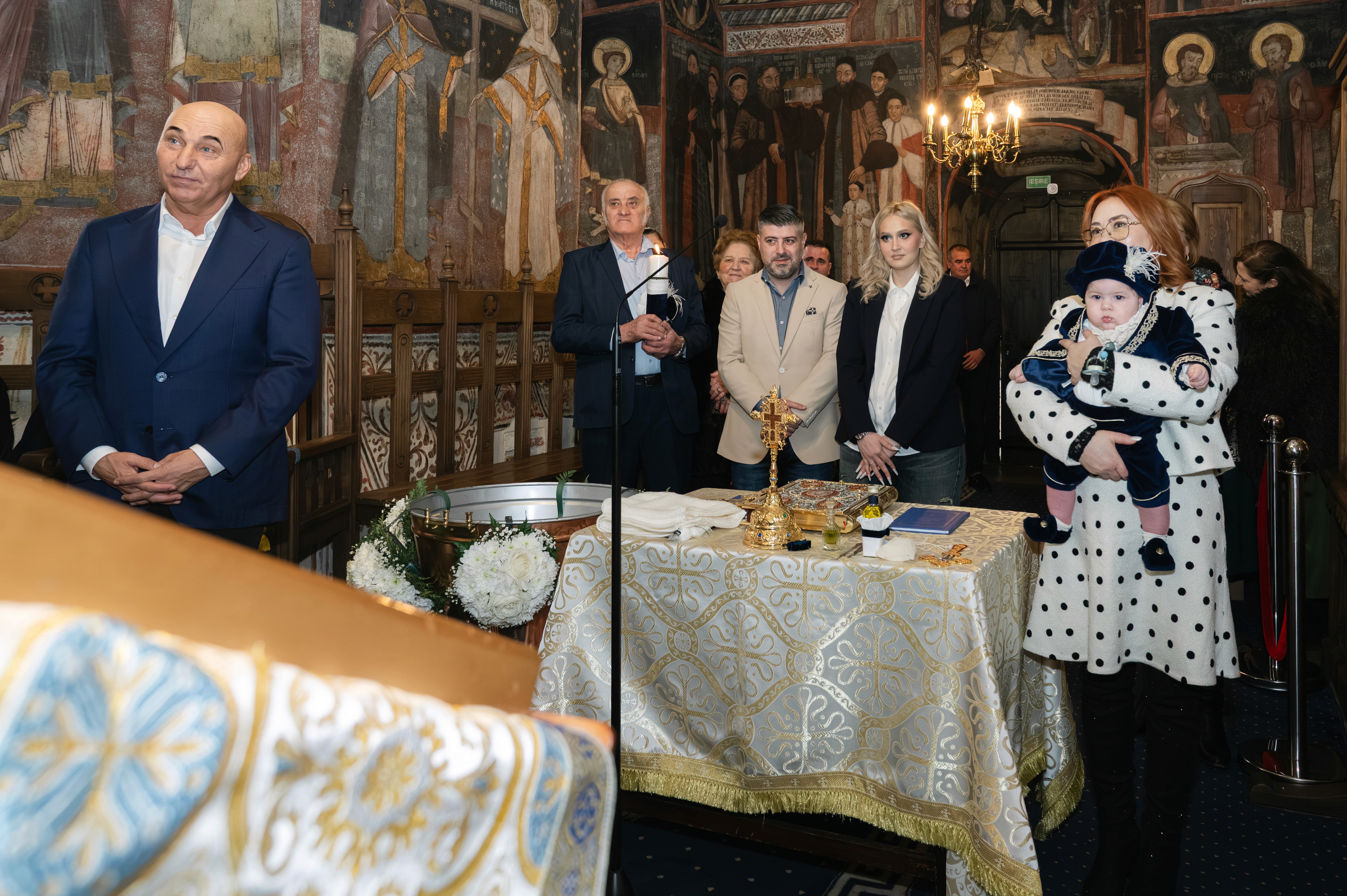 Familie și nași în fața altarului, fotografie de grup la botez.