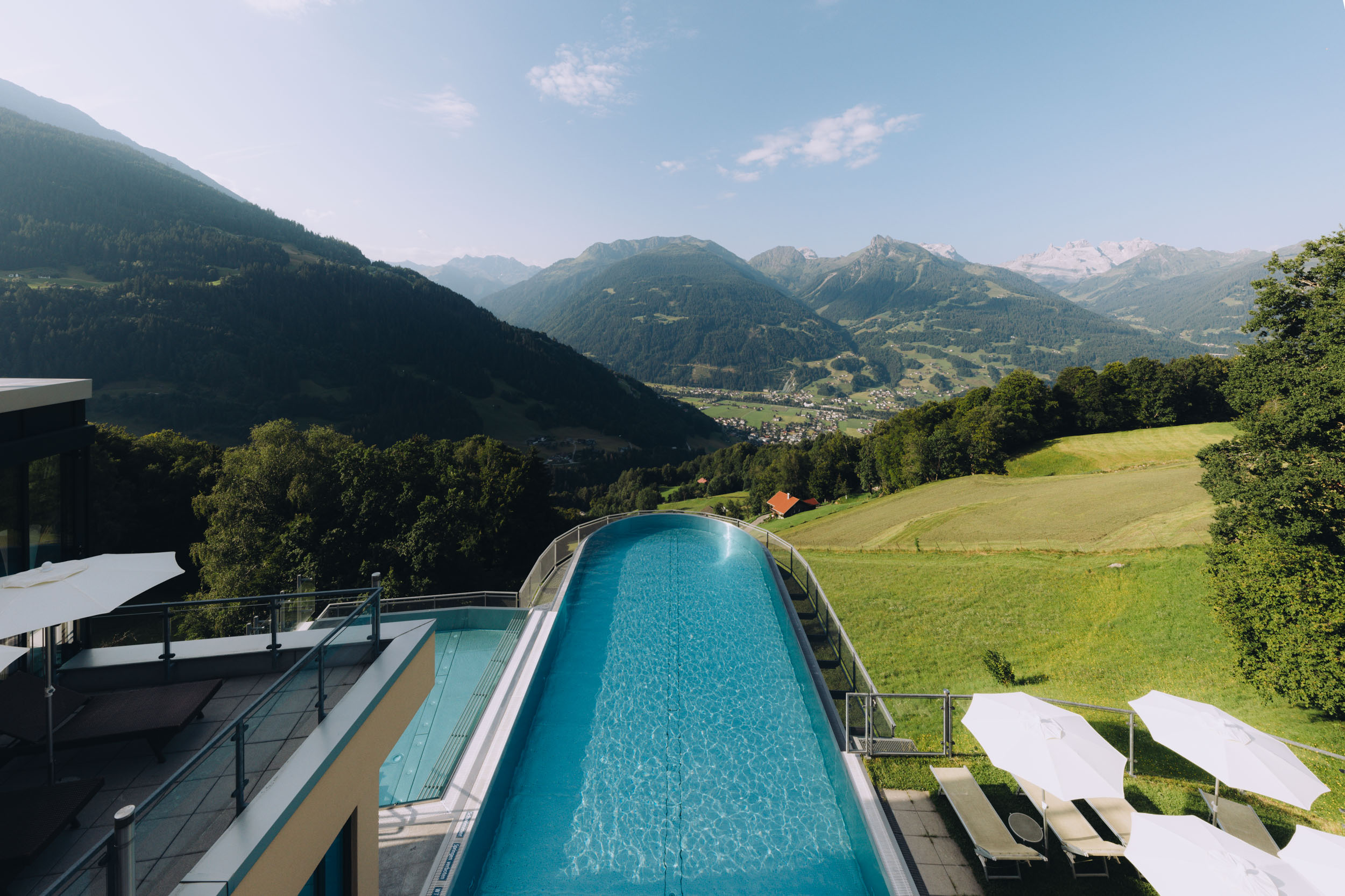 Infinity-Pool des Hotel Fernblick Montafon mit Blick auf Berge und Tal.