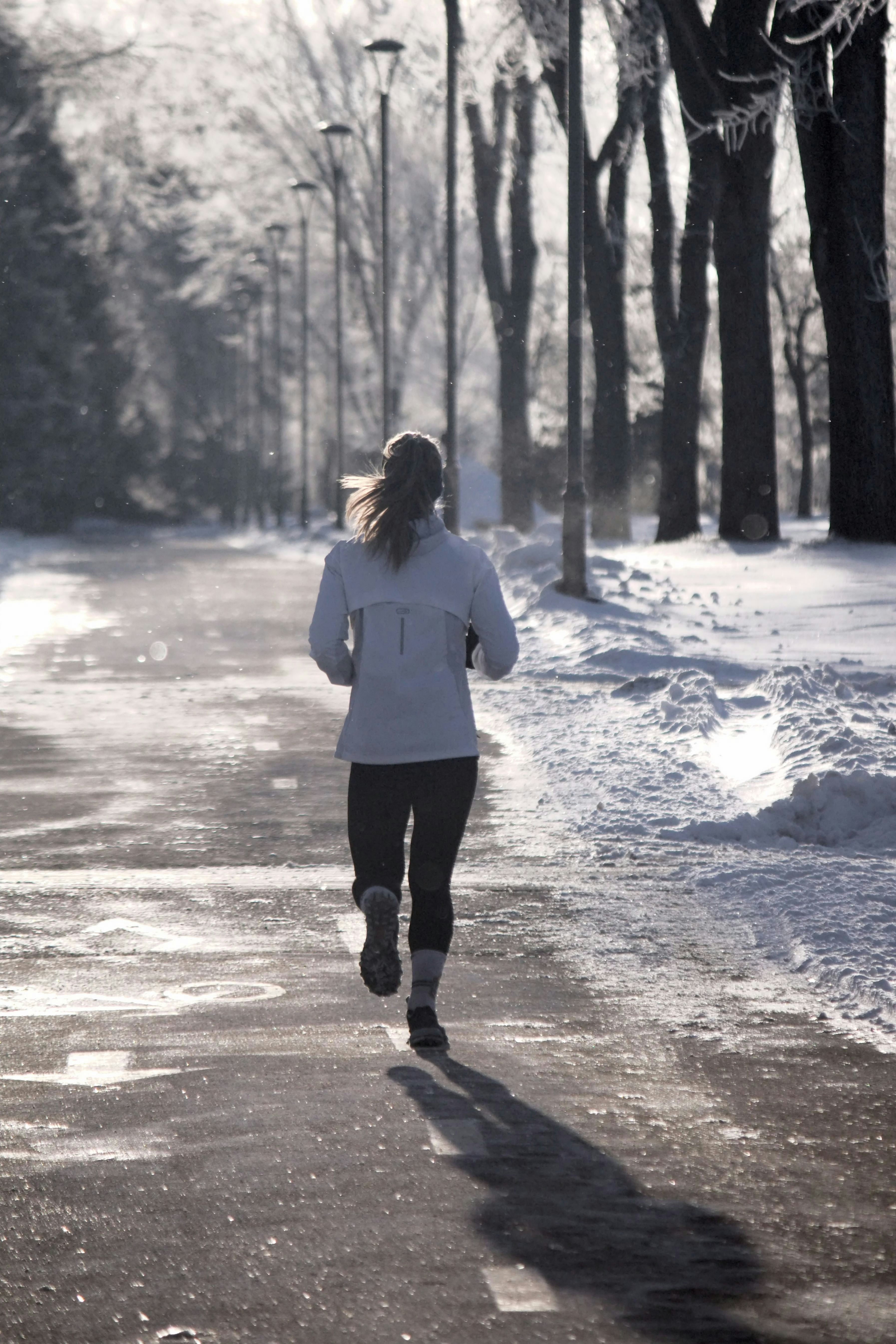 A woman running down a snow covered road