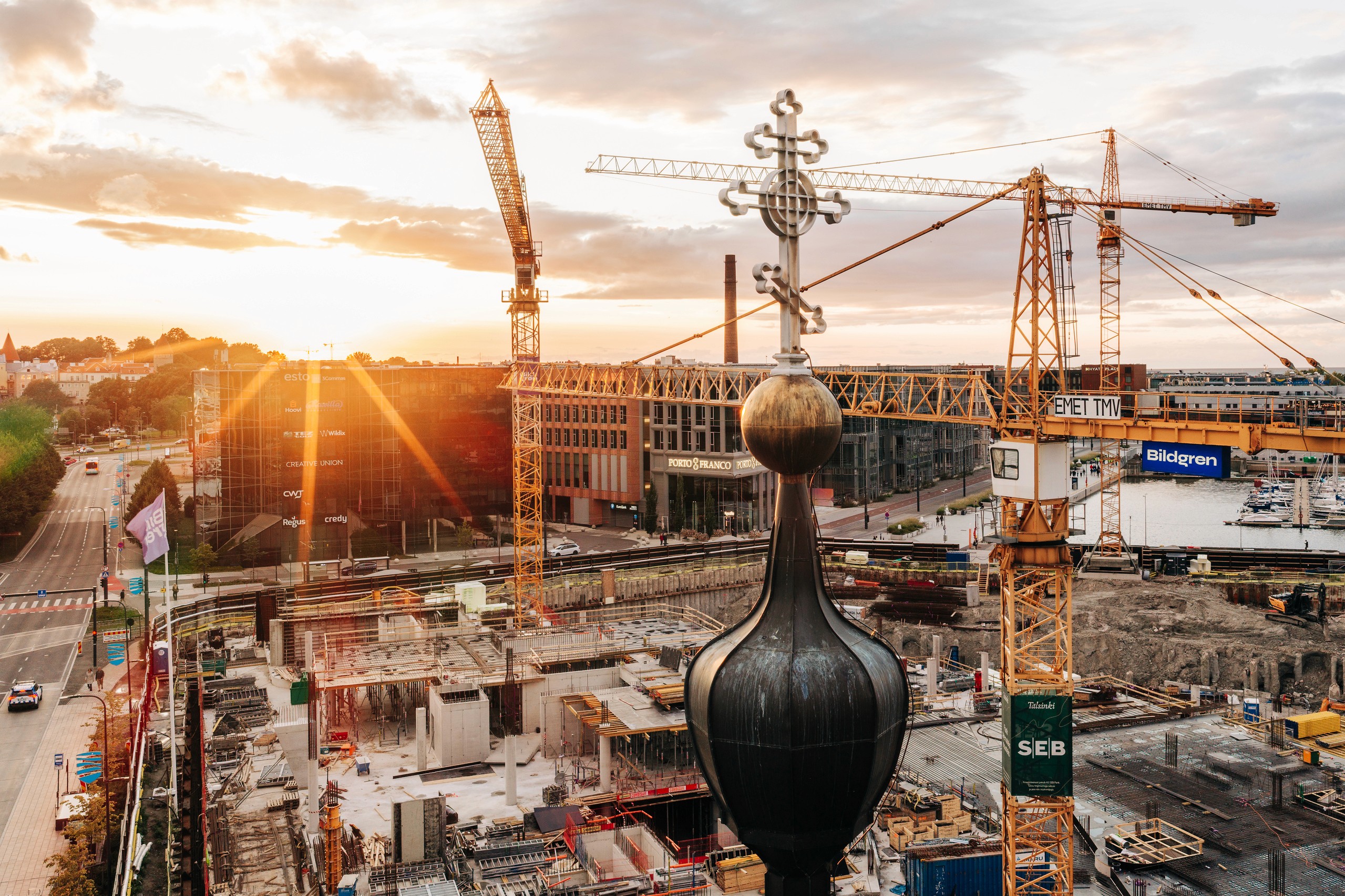 Talsinki construction progress, 11.08.2026: The low sun silhouettes cranes and the growing frame while still retaining readable vertical elements and site depth.