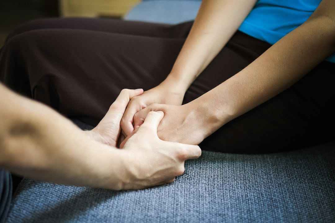 a close-up of a therapist’s hands using a voice-activated digital assistant in a bright clinic, focusing on the interface between human and technology, cinematic focus