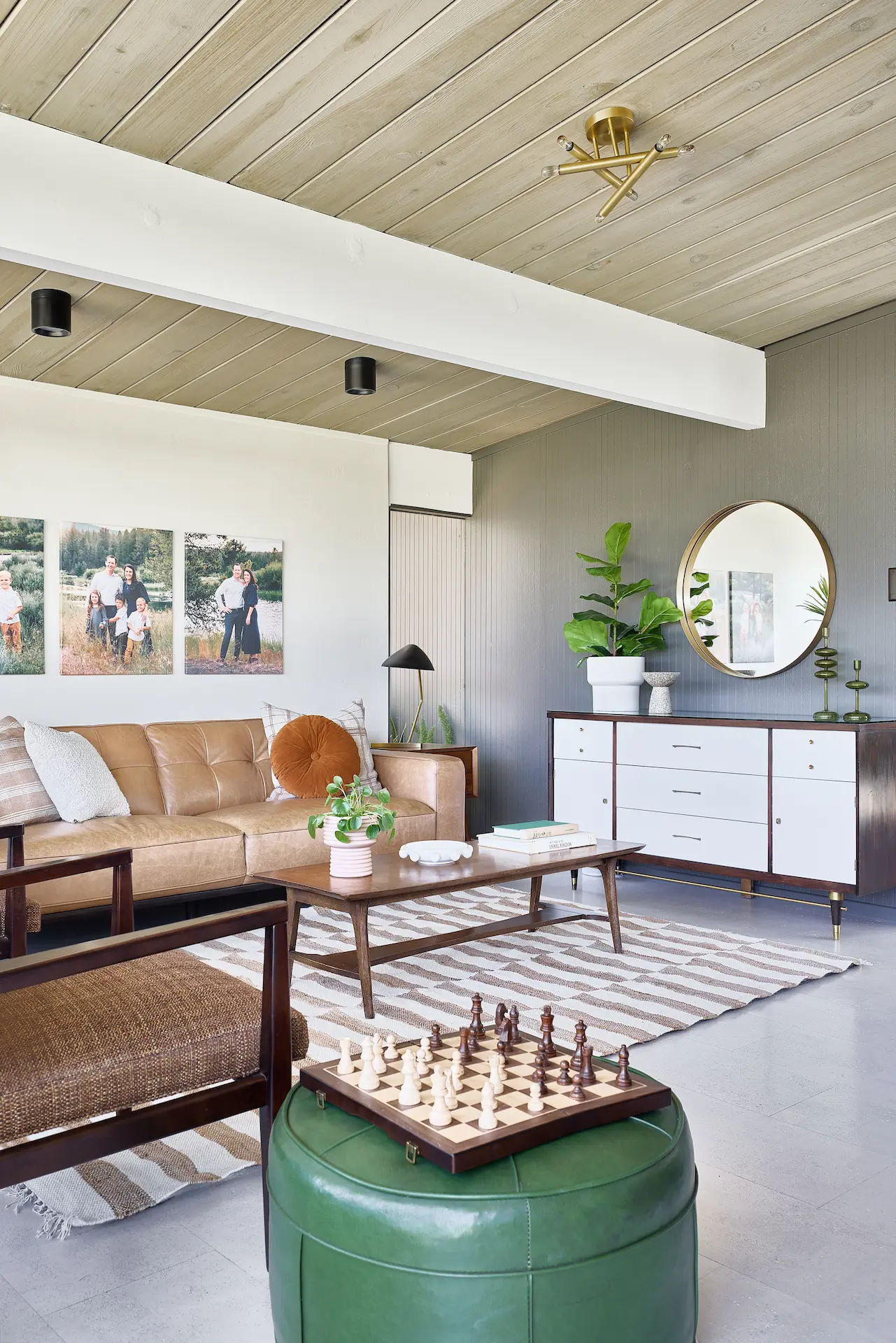 Portrait view of the integrated open kitchen and living space, featuring seating and furniture in the Fairhaven Eichler Tract remodel. Photo by Todd Huge.