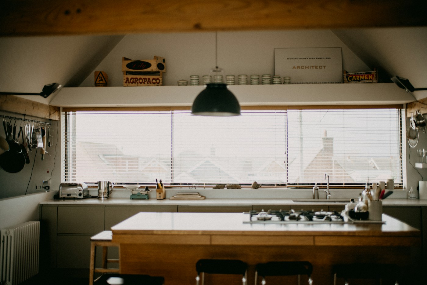 A kitchen under a long window with a timber worktop