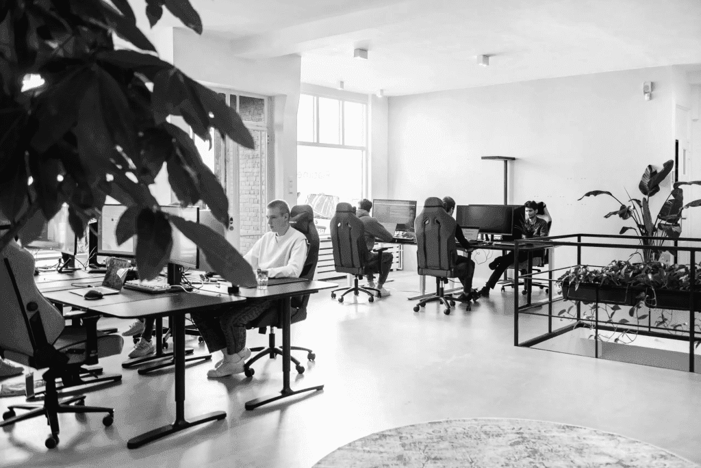 Open-plan Flatline Agency office with team members working at desks, in black and white