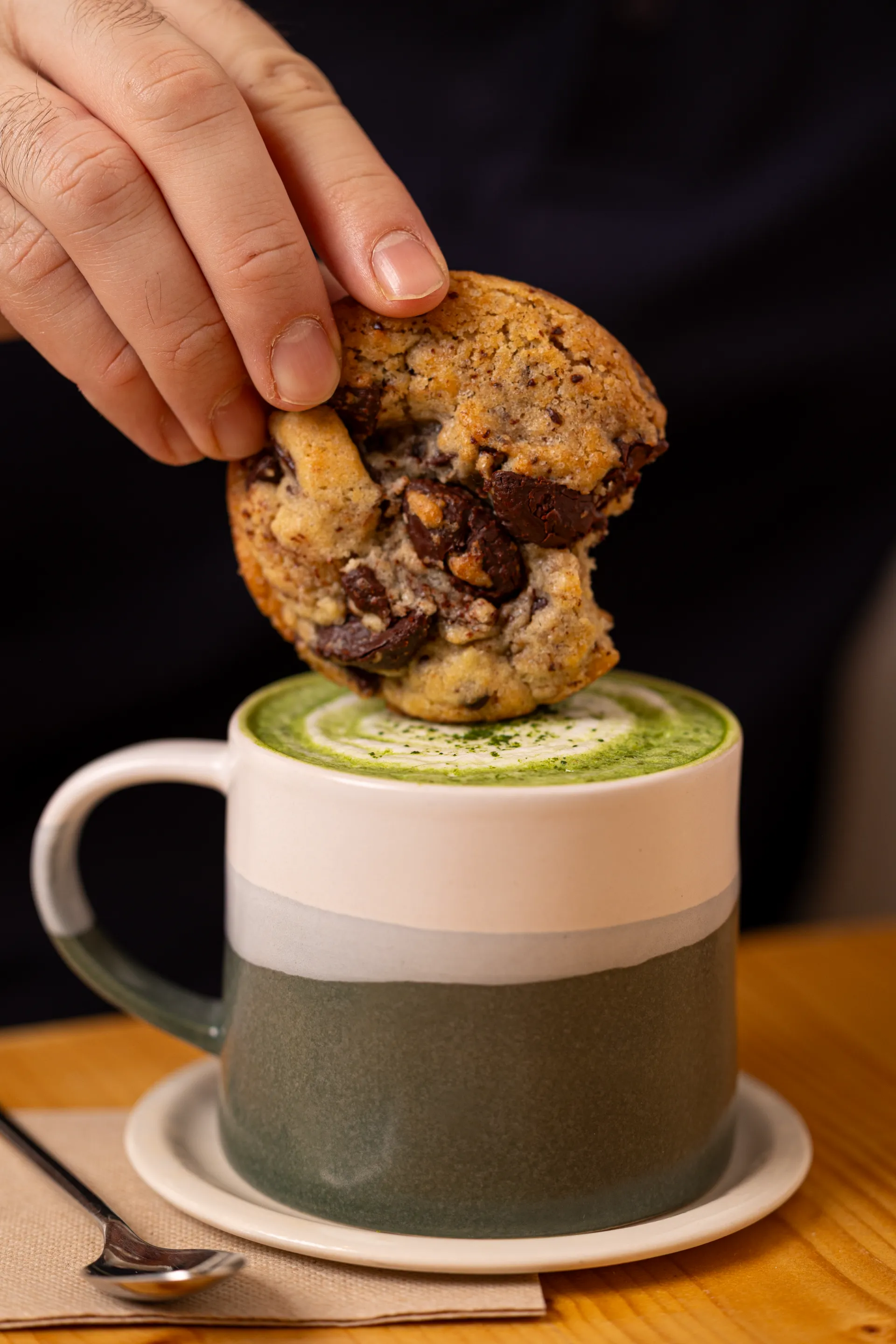 cookie moelleux qui est trempé dans une boisson matcha