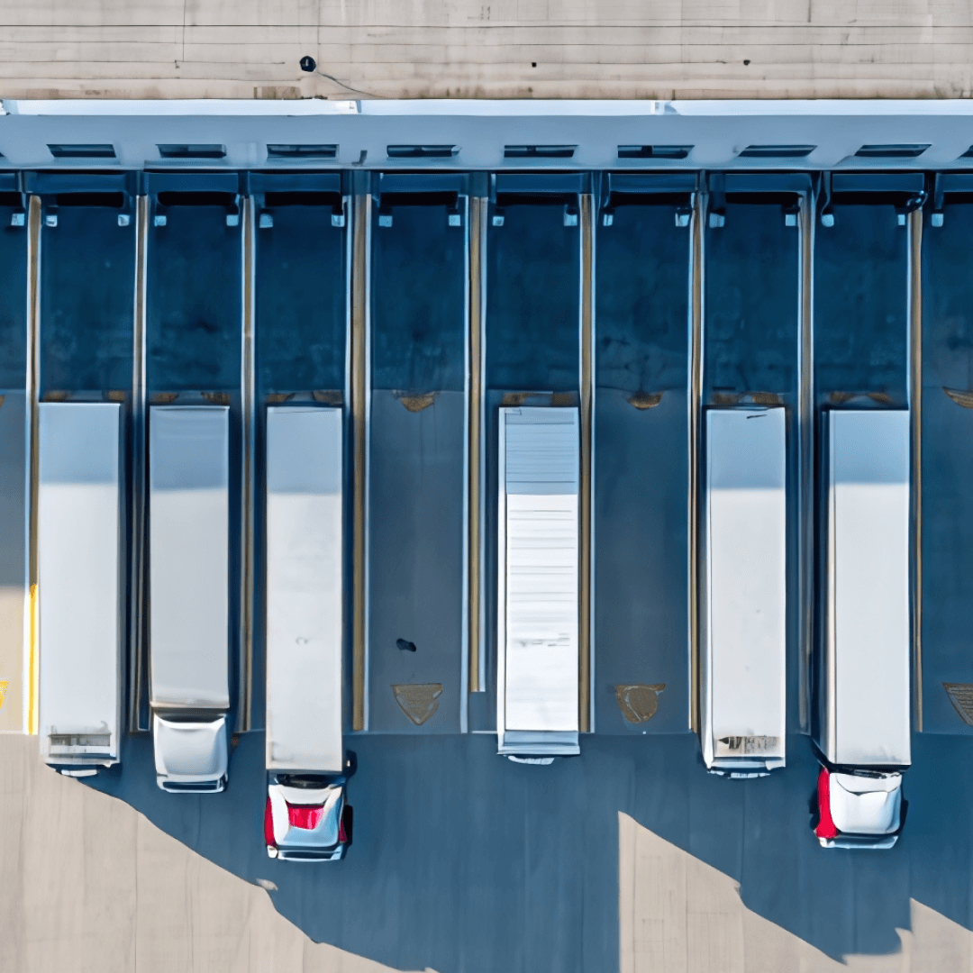 Trailers backed into warehouse docks coordinated through digital driver check-in and yard management system