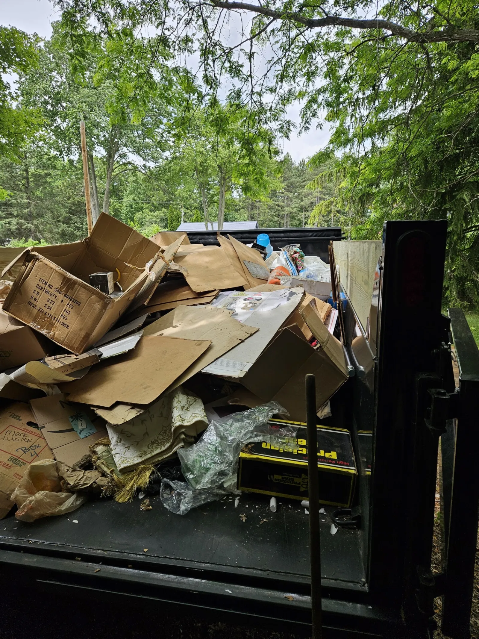 Dump trailer filled with flattened cardboard boxes and household junk from a cleanout