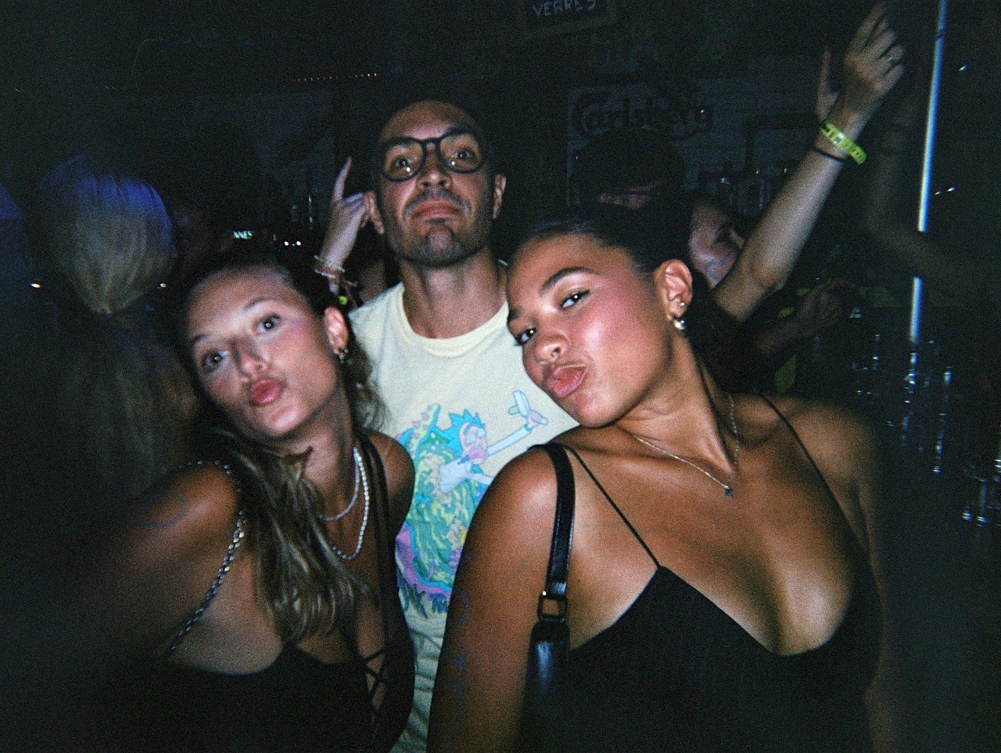 Travelers checking their phones and meeting at night in Nice before starting a bar crawl through lively streets and bars.