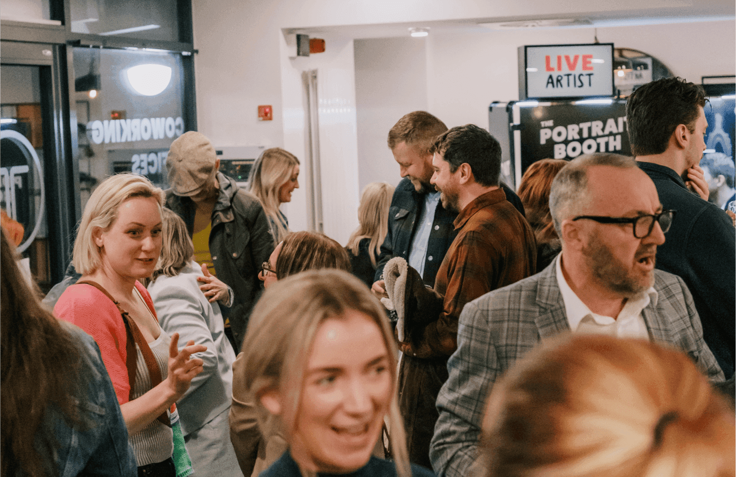 People standing and talking in a busy train station.