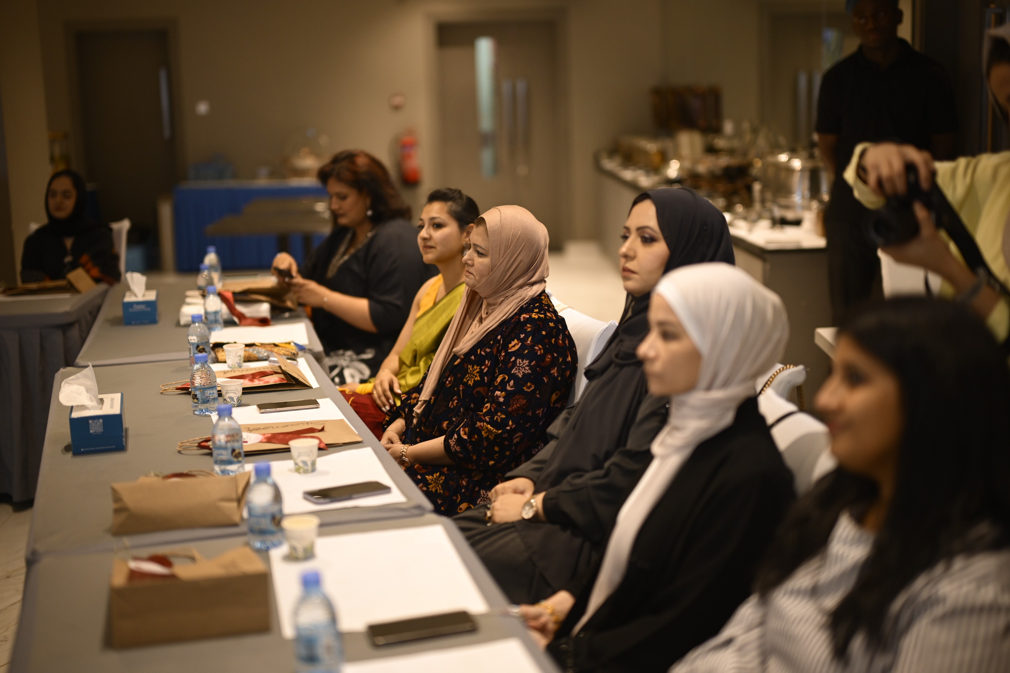 A winding road cuts through rocky terrain, surrounded by patches of green grass and illuminated by sunlight.