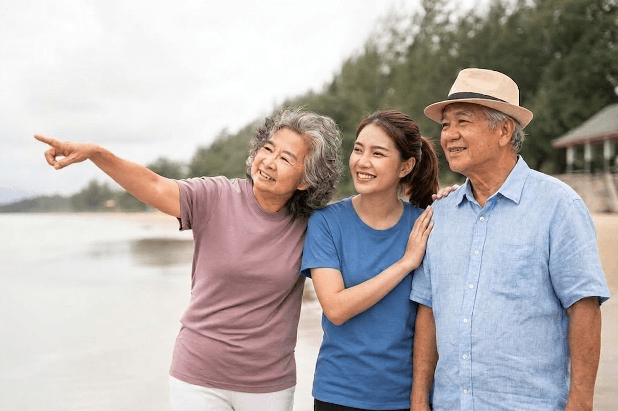Group of people standing around a white desk during a casual meeting with laptops and coffee cups.