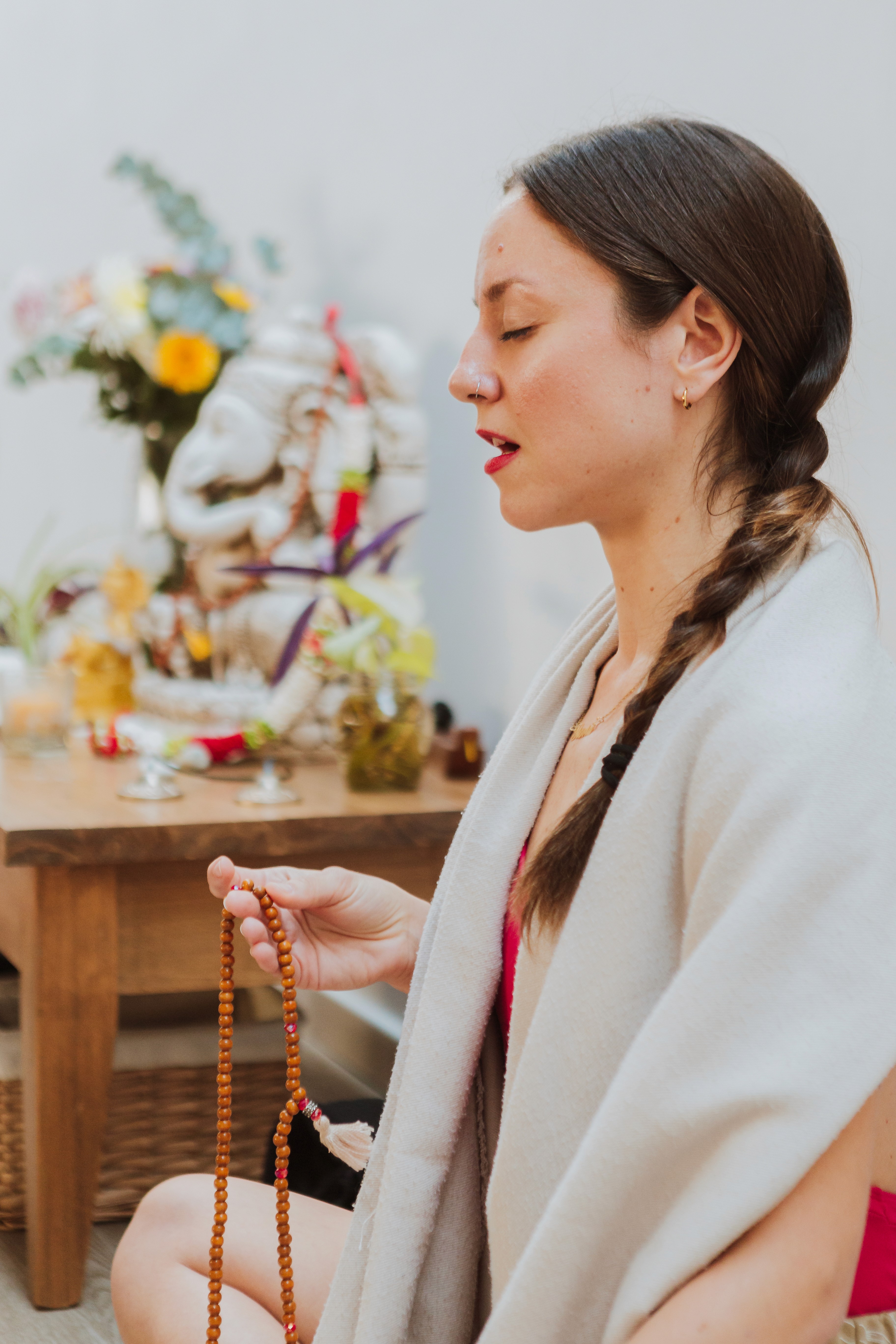 Flavia Siutti sosteniendo un mala de meditación en un espacio interior