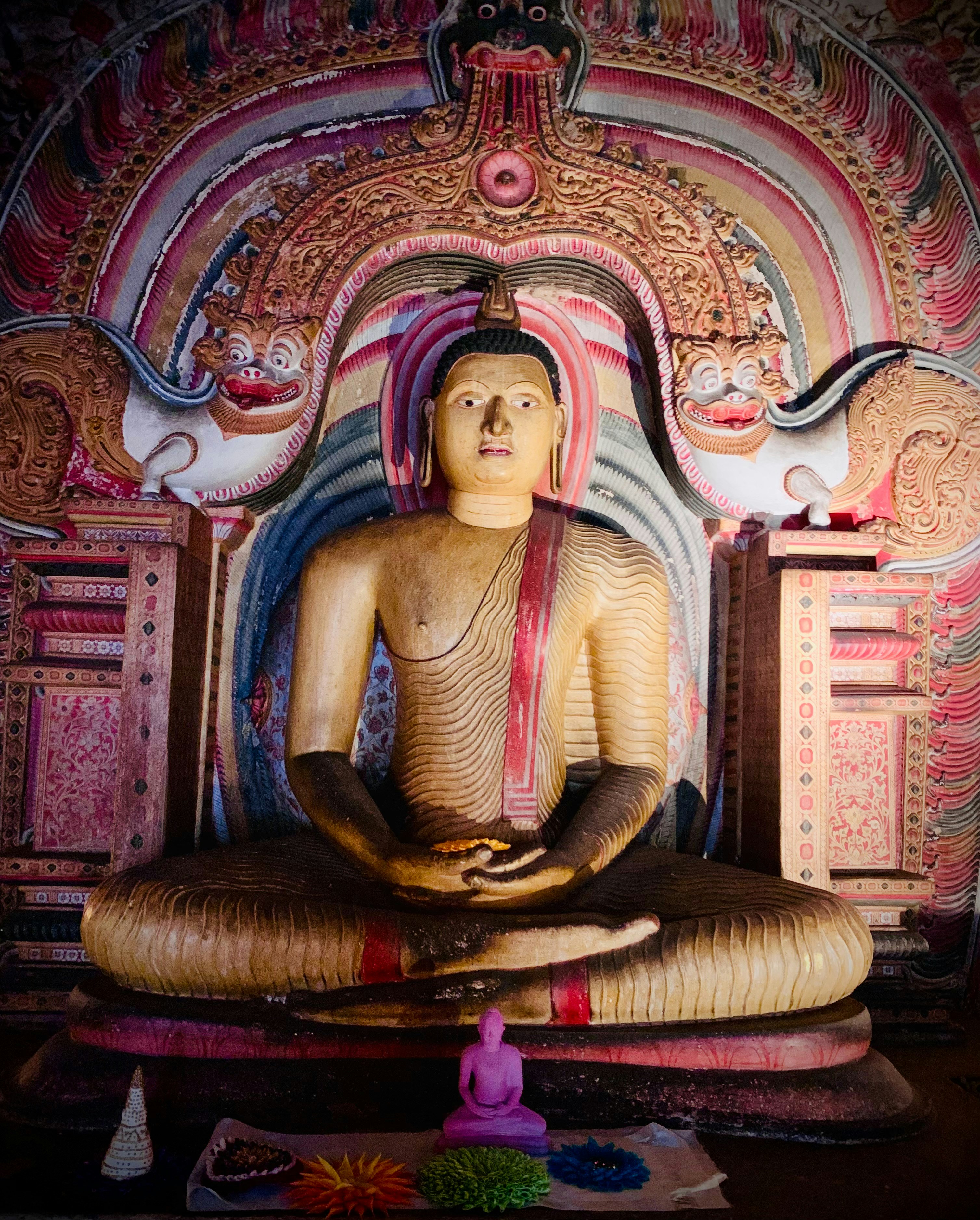 A seated buddha statue in a colorful temple.