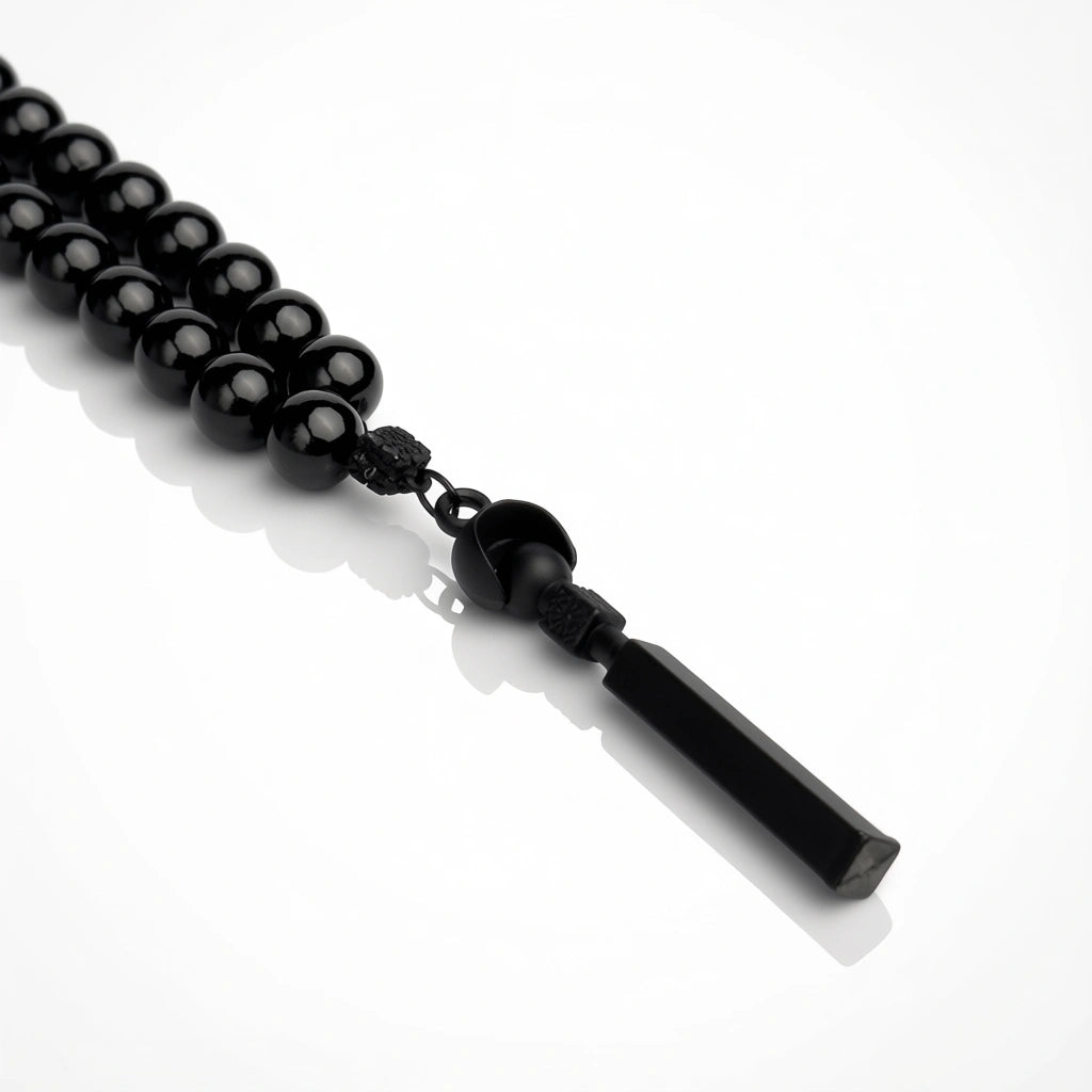 Black beaded necklace with a tassel on a white background