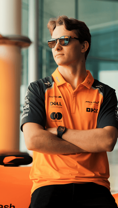 Two models facing each other in a wheat field, holding hands.